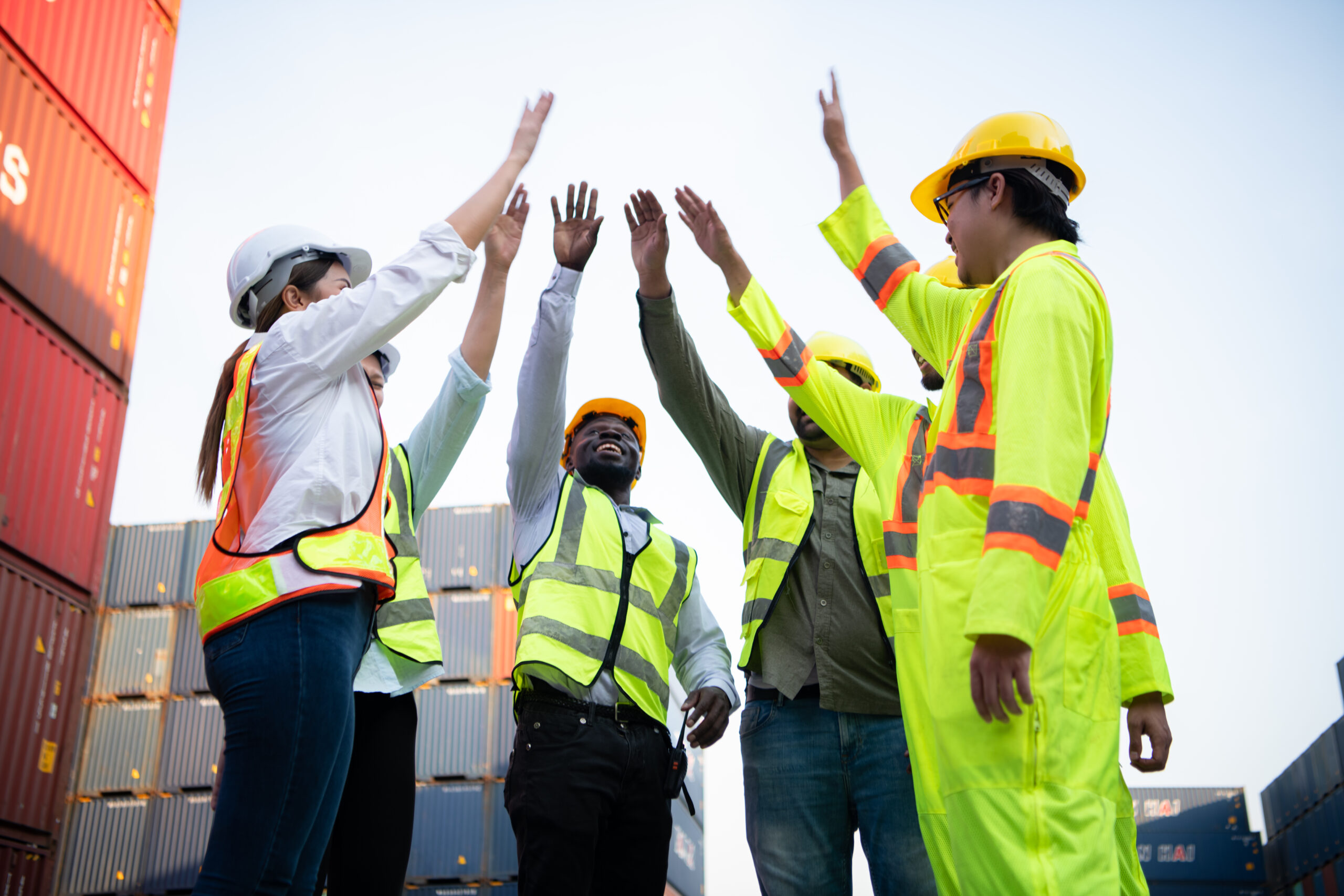 A Group Of Happy Team Workers Stood Hand In Hand To Show Their S